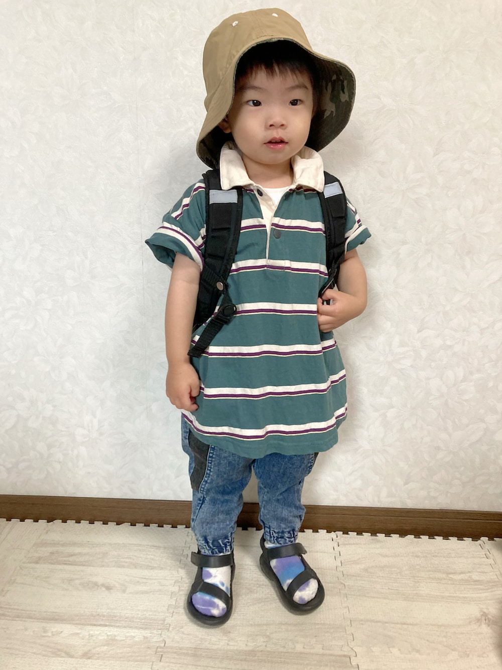 グリーン系のポロシャツ、ブルー系のデニムパンツ、ブラック系のバックパック/リュックを着用したキッズの夏コーディネートの3枚目の写真