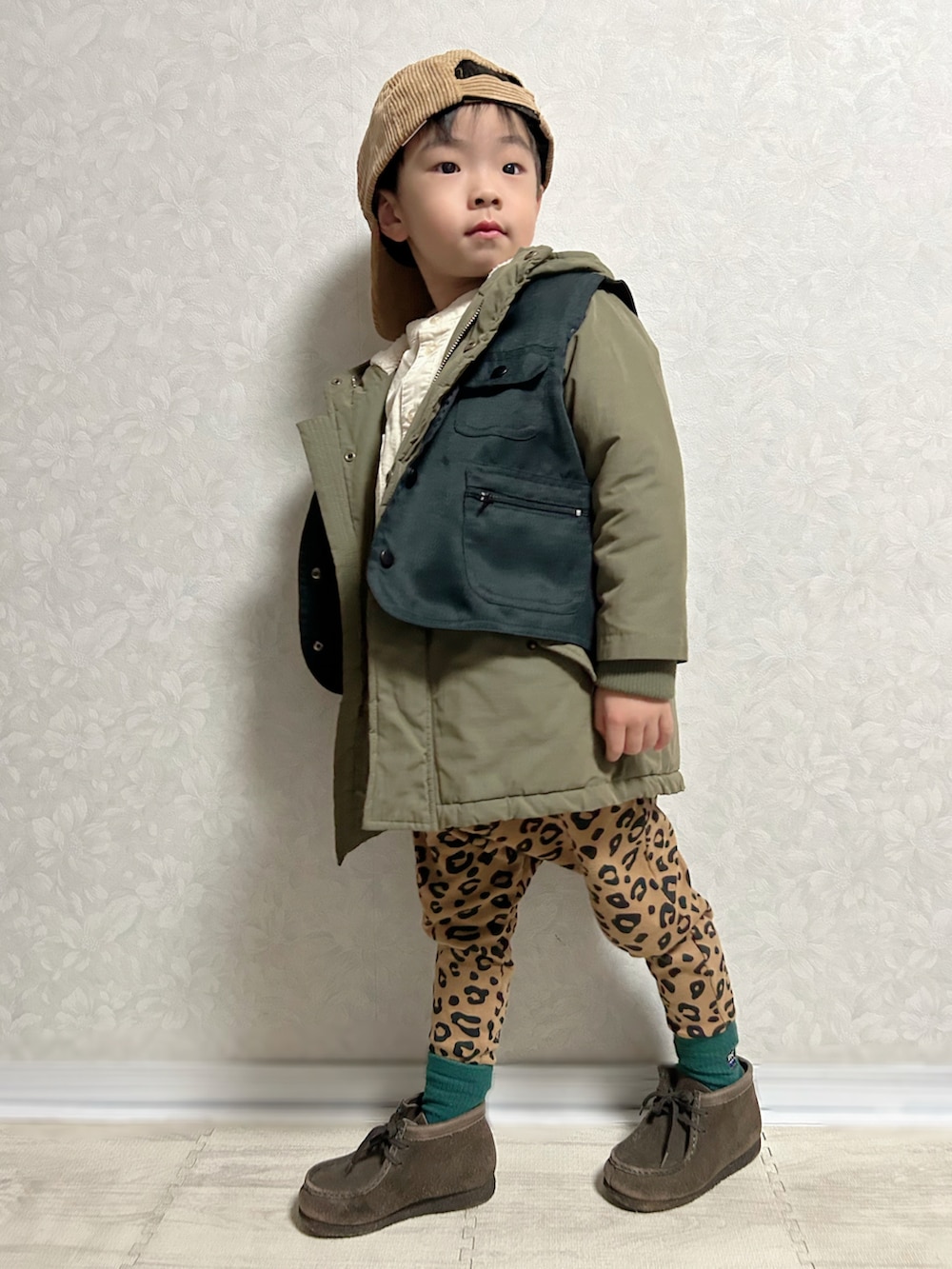 ホワイト系のシャツ/ブラウス、グリーン系のモッズコート、ブラック系のベストを着用したキッズの秋コーディネートの3枚目の写真
