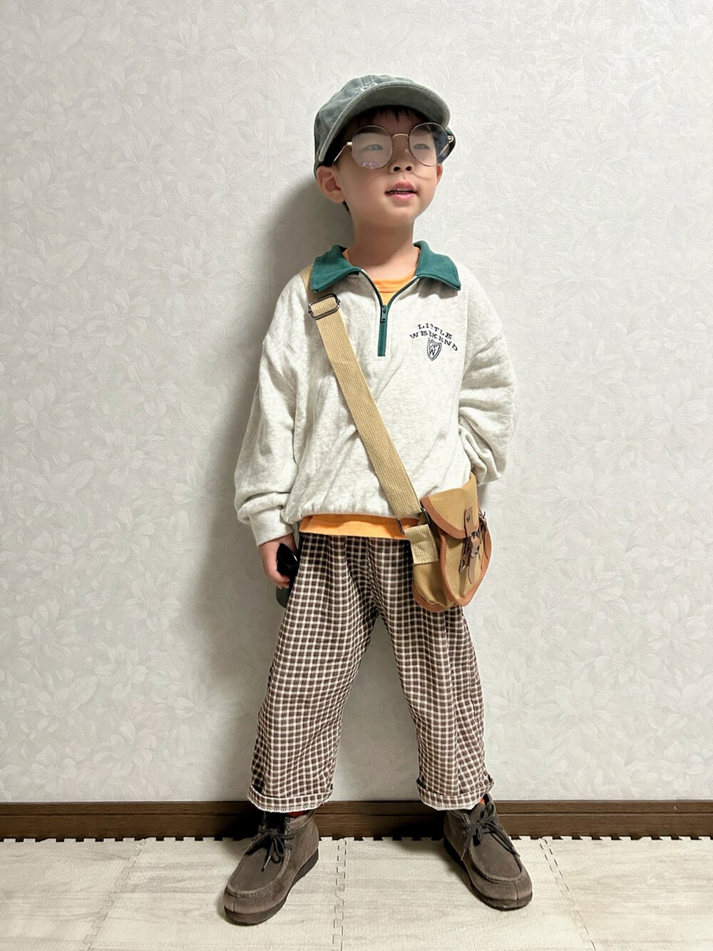 オレンジ系のタンクトップ、グレー系のスウェット、ブラウン系のパンツを着用したキッズの秋コーディネートの4枚目の写真