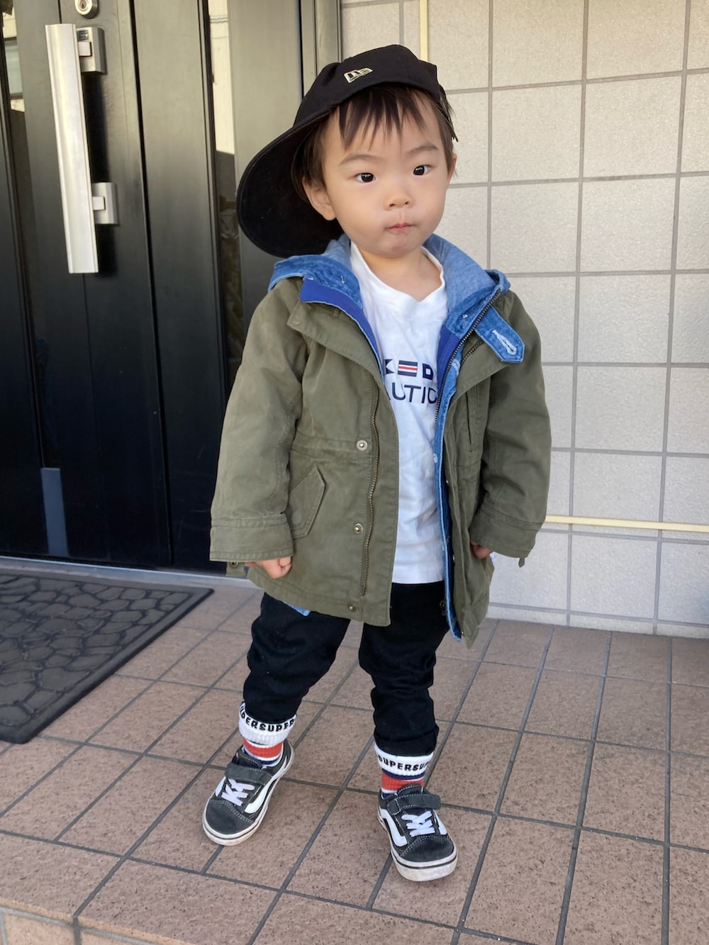 ホワイト系のTシャツ/カットソー、ブルー系のデニムジャケット、グリーン系のミリタリージャケットを着用したキッズの冬コーディネートの2枚目の写真