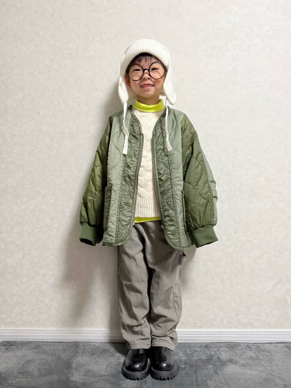 グリーン系のブルゾン、グレー系のカーゴパンツ、イエロー系のTシャツ/カットソーを着用したキッズの秋コーディネートの2枚目の写真