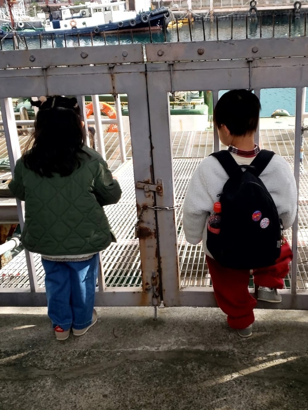 レッド系のセットアップ、レッド系のシャツ/ブラウス、グリーン系のノーカラージャケットを着用したキッズの冬コーディネートの3枚目の写真