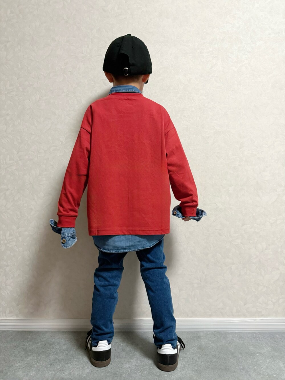 レッド系のTシャツ/カットソー、ブルー系のデニムパンツ、ブラック系のスニーカーを着用したキッズの秋コーディネートの3枚目の写真
