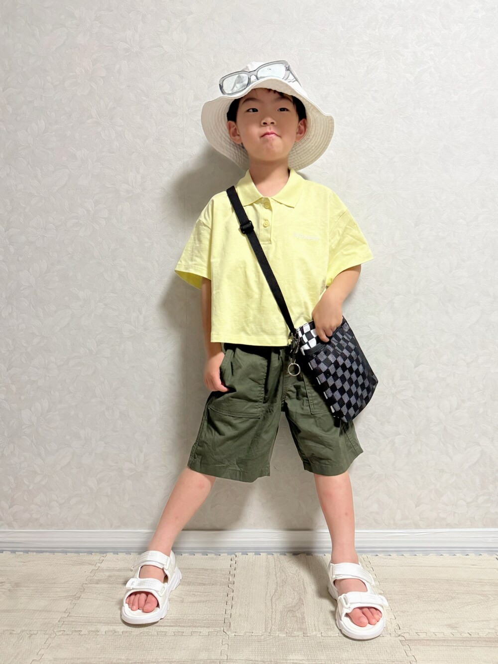 その他のショルダーバッグ、イエロー系のポロシャツ、グリーン系のチノパンツを着用したキッズの夏コーディネートの2枚目の写真