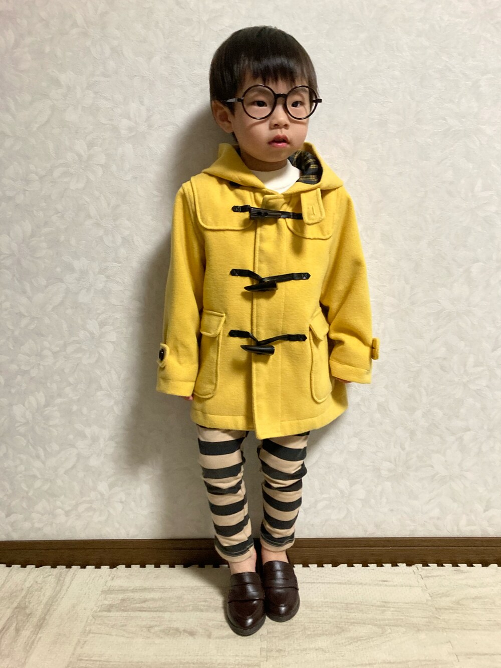 ホワイト系のニット/セーター、イエロー系のダッフルコート、ブラック系のその他パンツを着用したキッズの冬コーディネートの3枚目の写真