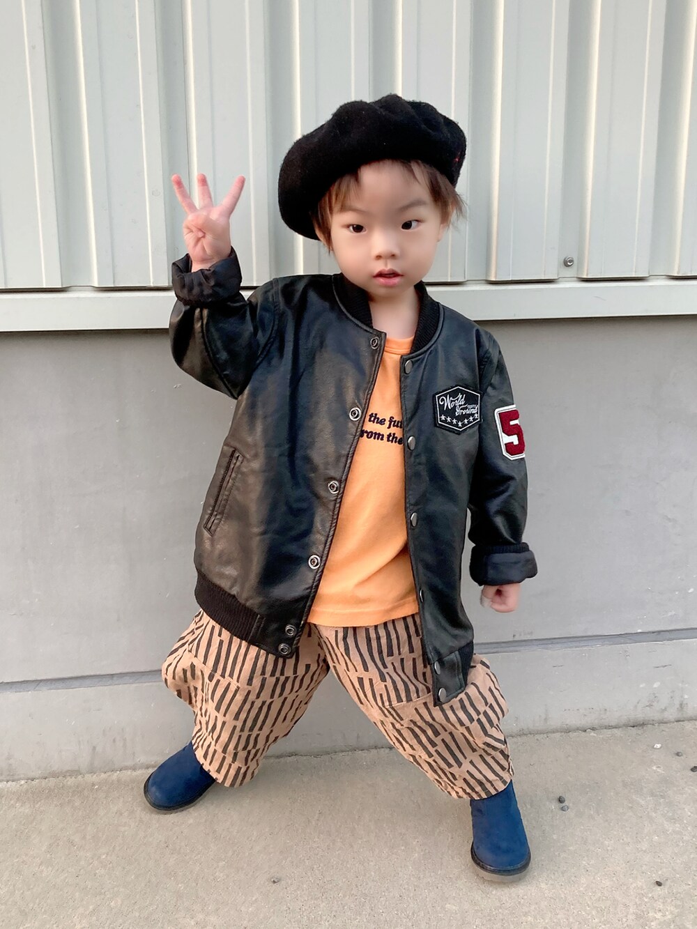 ブラウン系のジャケット/アウター、ブラック系のスカート、ブラック系のブーツを着用したキッズの秋コーディネートの3枚目の写真