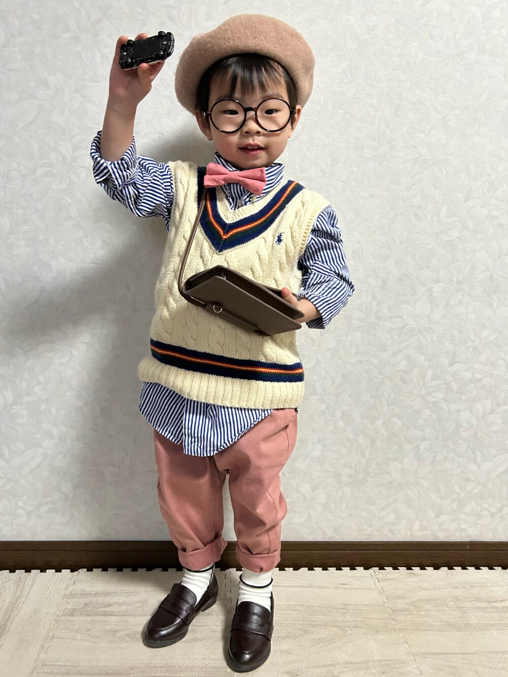 ブルー系のシャツ/ブラウス、ホワイト系のベスト、レッド系の蝶ネクタイを着用したキッズの冬コーディネートの5枚目の写真