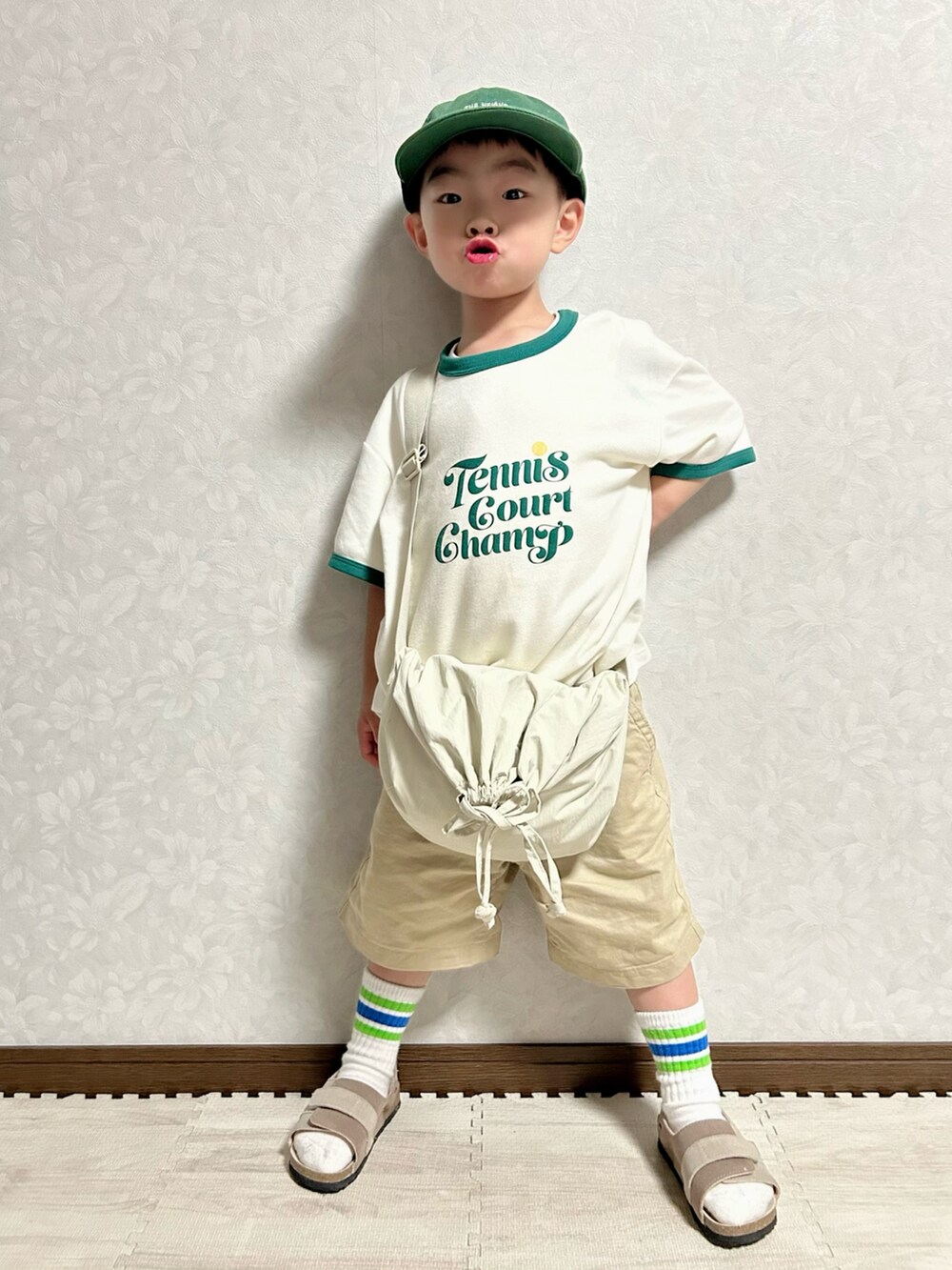 ホワイト系のTシャツ/カットソー、ホワイト系のショルダーバッグ、ベージュ系のチノパンツを着用したキッズの春コーディネートの2枚目の写真