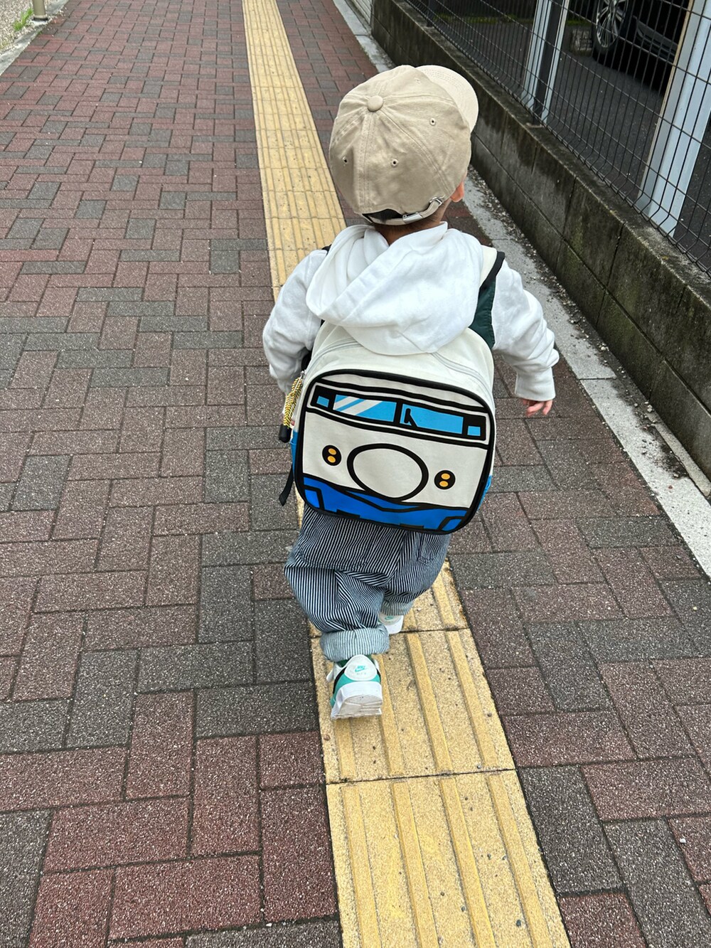 ピンク系のTシャツ/カットソー、ホワイト系のパーカー、グリーン系のベストを着用したキッズの春コーディネートの4枚目の写真