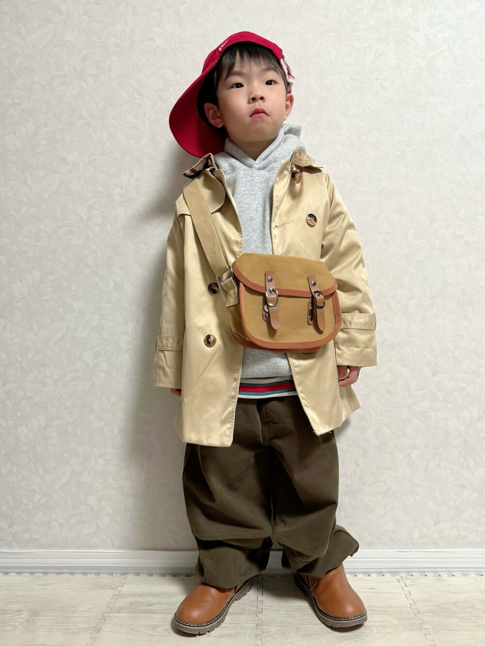 グレー系のパーカー、レッド系のTシャツ/カットソー、ブラウン系のショルダーバッグを着用したキッズの春コーディネートの2枚目の写真