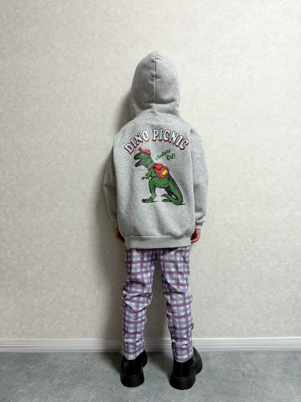 グレー系のパーカー、ブラック系のブーツ、パープル系のレギンス/スパッツを着用したキッズの秋コーディネートの2枚目の写真