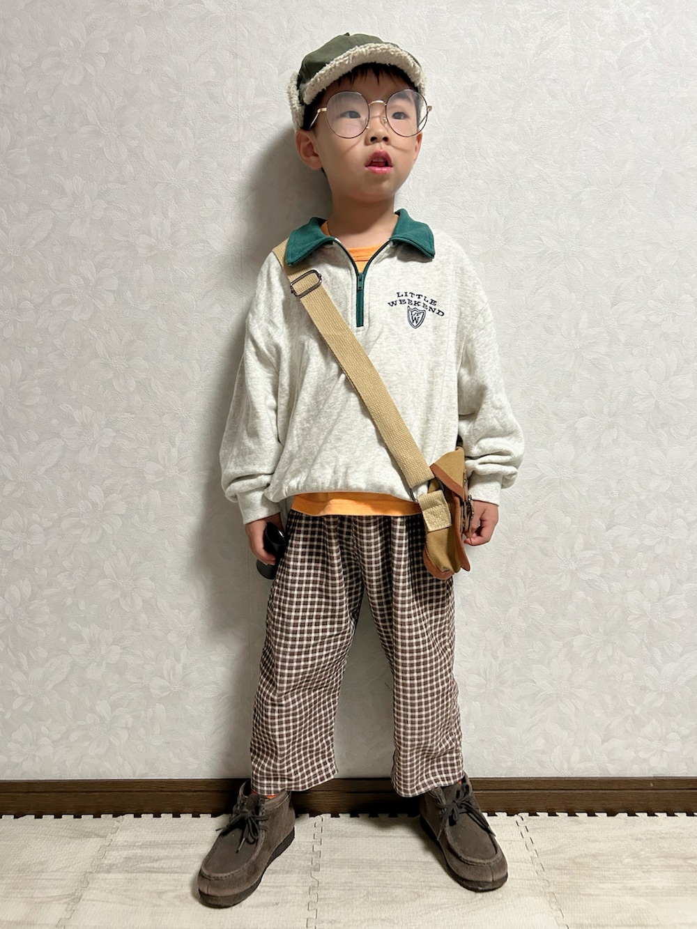 オレンジ系のタンクトップ、グレー系のスウェット、ブラウン系のパンツを着用したキッズの秋コーディネートの5枚目の写真