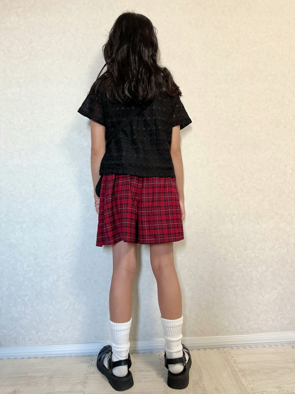 ブラック系のTシャツ/カットソー、レッド系のスカート、ブラック系のショルダーバッグを着用したキッズの夏コーディネートの2枚目の写真