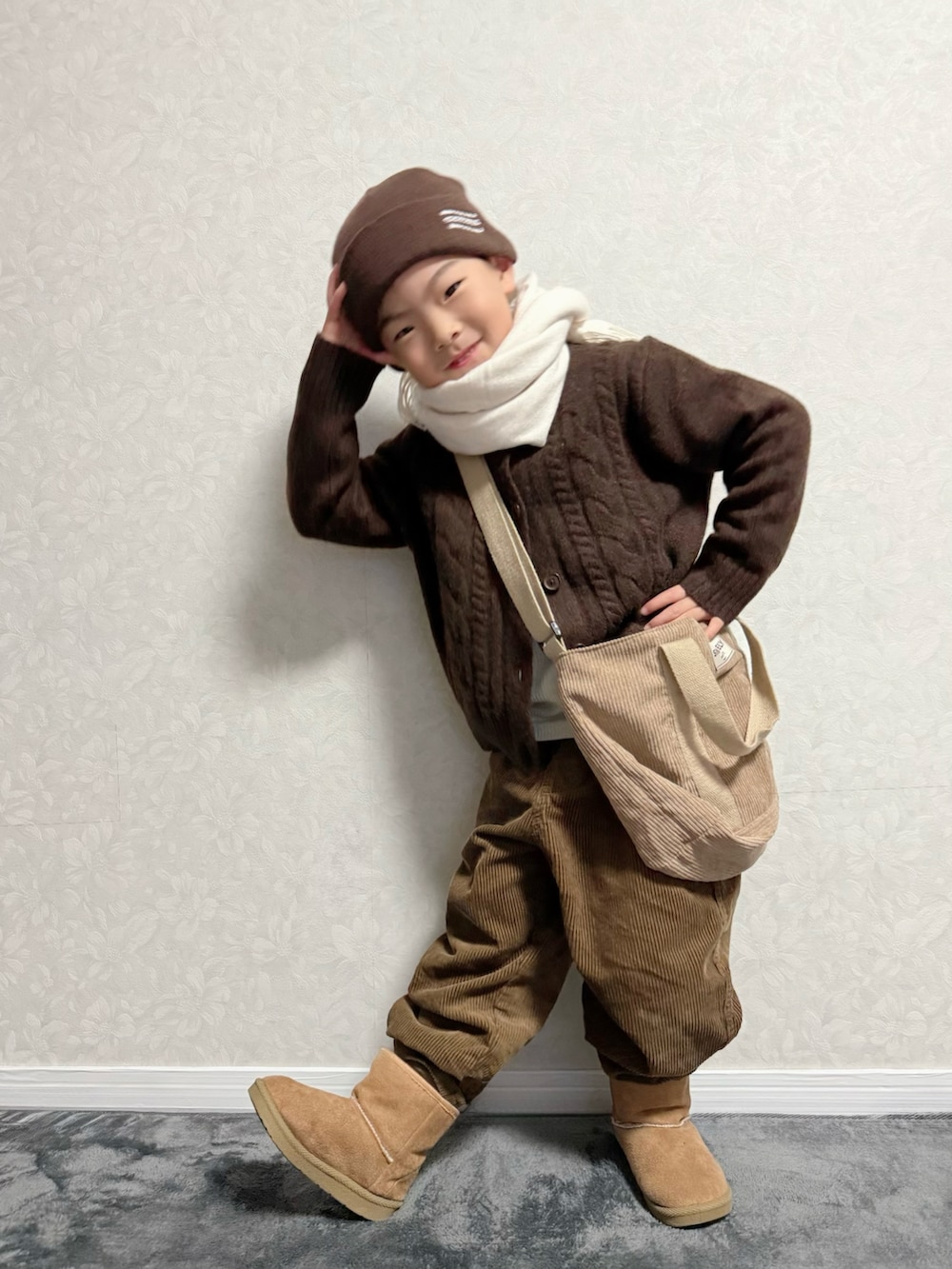 ブラウン系のカーディガン/ボレロ、ホワイト系のTシャツ/カットソー、ブラウン系のパンツを着用したキッズの冬コーディネートの5枚目の写真