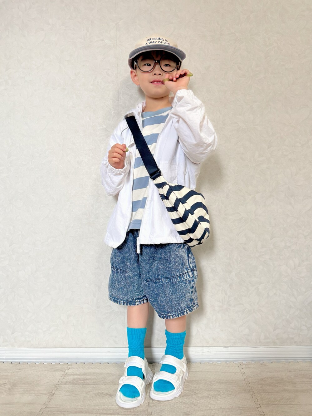 ブルー系のTシャツ/カットソー、ホワイト系のナイロンジャケット、ホワイト系のショルダーバッグを着用したキッズの春コーディネートの3枚目の写真
