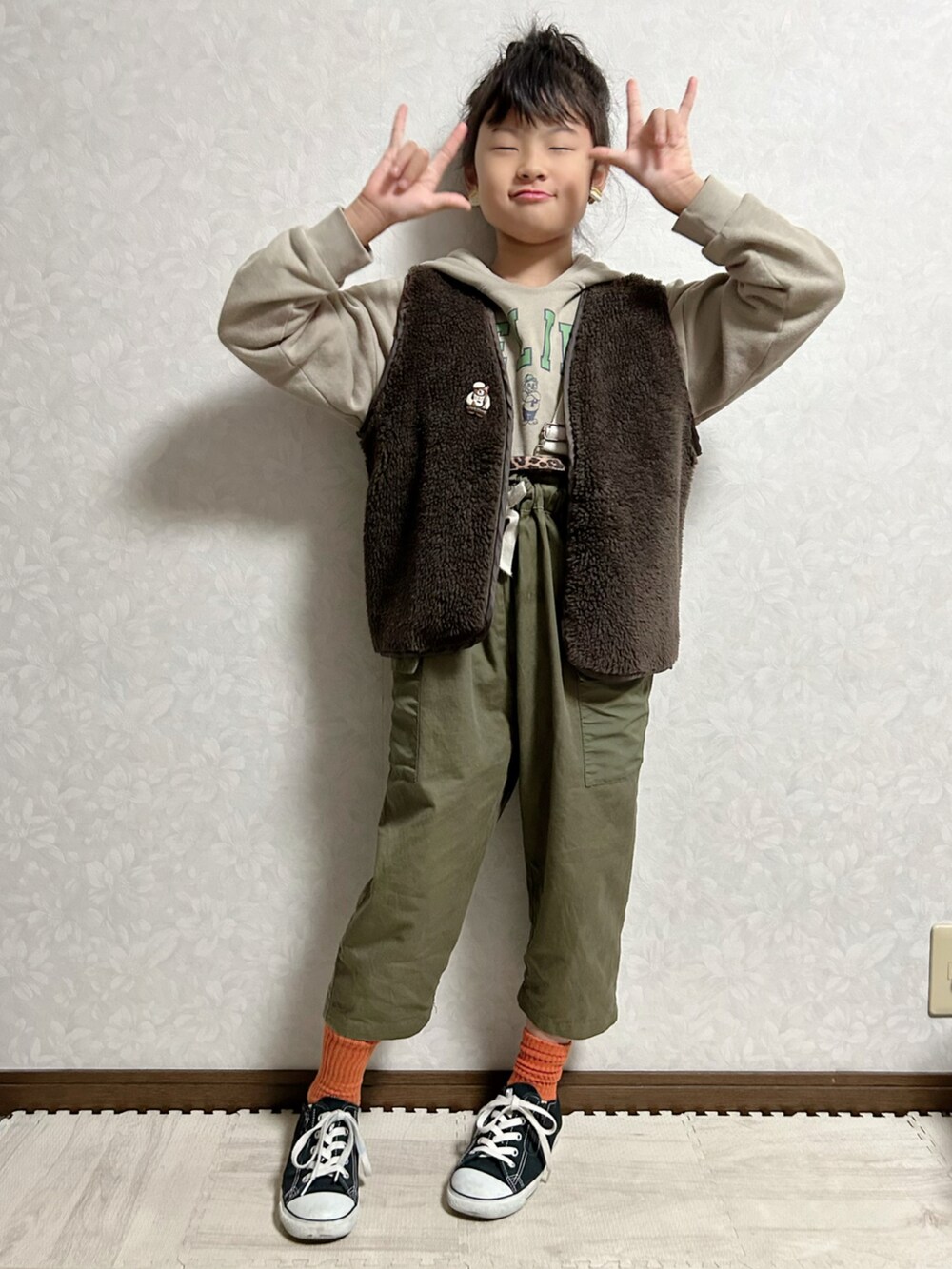 ベージュ系のパーカー、グリーン系のスウェット、グリーン系のサロペット/オーバーオールを着用したキッズの冬コーディネートの3枚目の写真