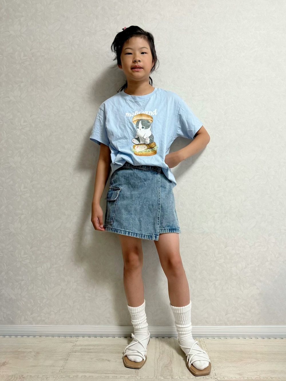 ブルー系のTシャツ/カットソー、ブルー系のデニムスカート、ブラック系のサンダルを着用したキッズの夏コーディネートの2枚目の写真