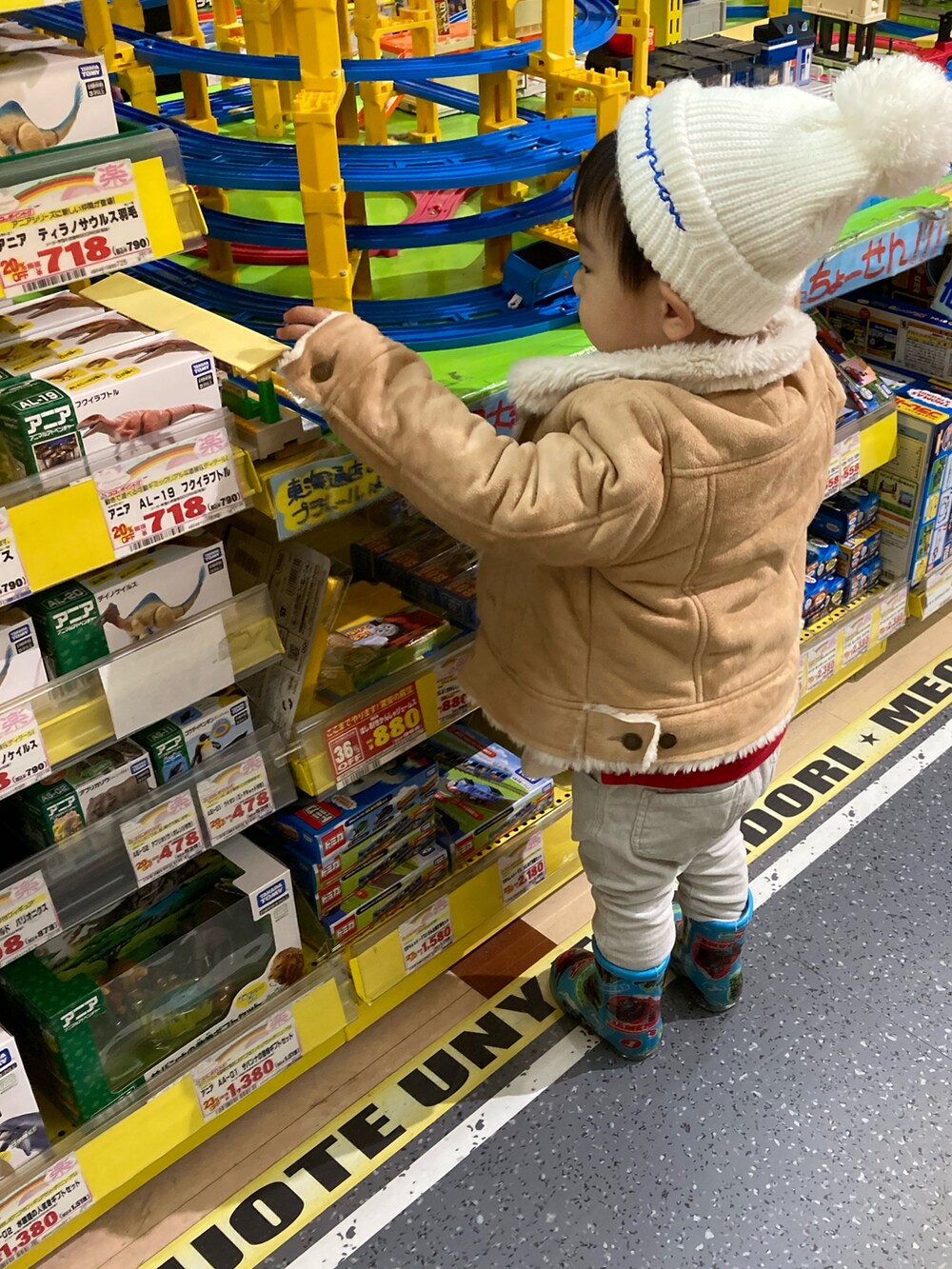 レッド系のスウェット、ベージュ系のその他パンツ、ホワイト系のTシャツ/カットソーを着用したキッズの冬コーディネートの5枚目の写真