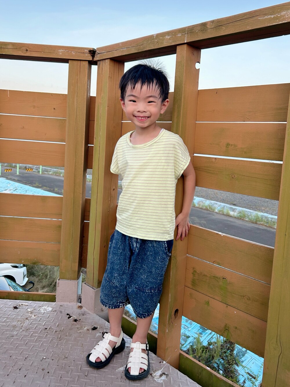 イエロー系のTシャツ/カットソー、ブルー系のデニムパンツ、ホワイト系のサンダルを着用したキッズの夏コーディネートの2枚目の写真