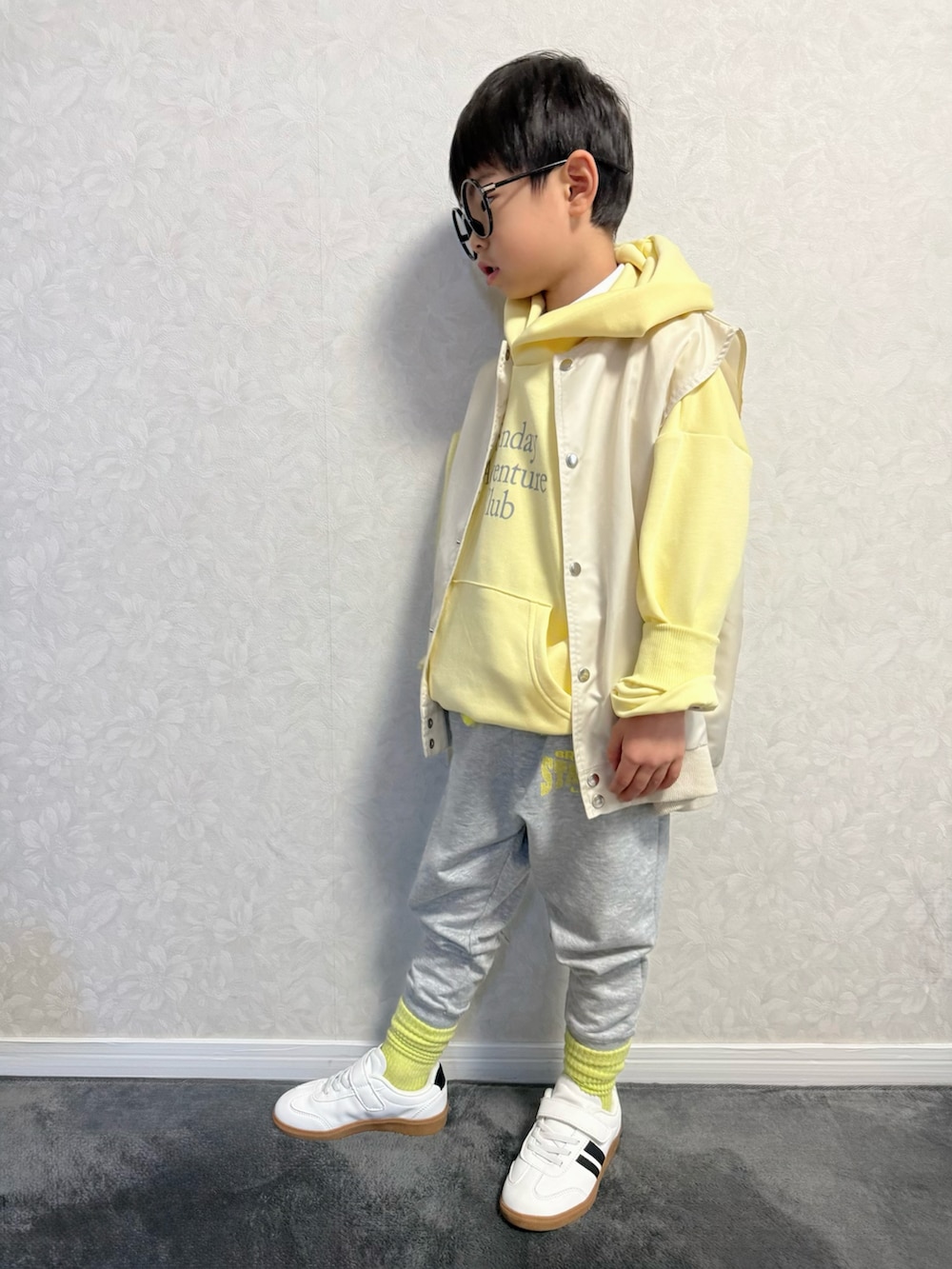 ベージュ系のベスト、グレー系のスウェットパンツ、シルバー系のショルダーバッグを着用したキッズの冬コーディネートの4枚目の写真