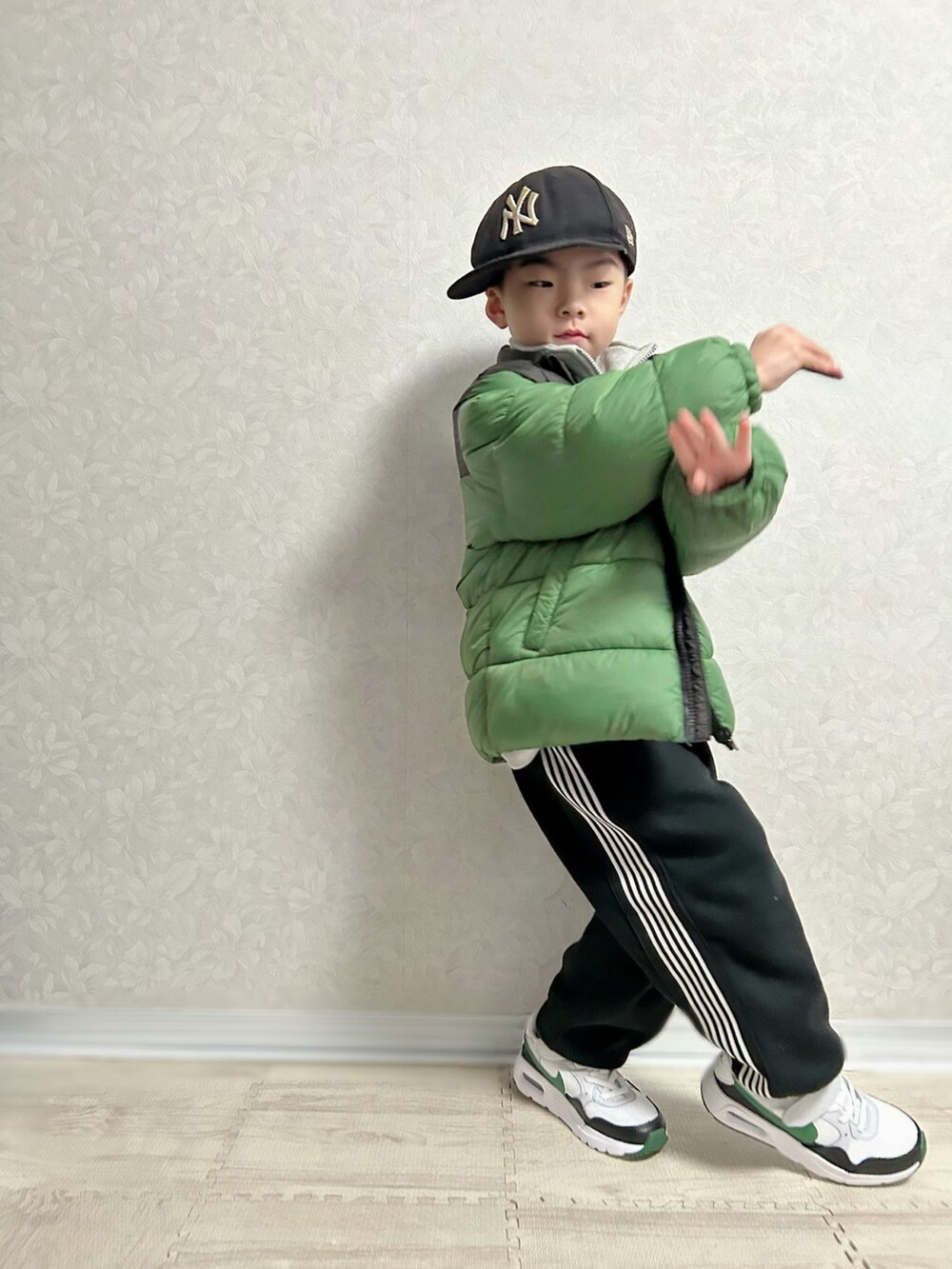 レッド系のTシャツ/カットソー、グレー系のスウェット、グリーン系のダウンジャケット/コートを着用したキッズの冬コーディネートの3枚目の写真