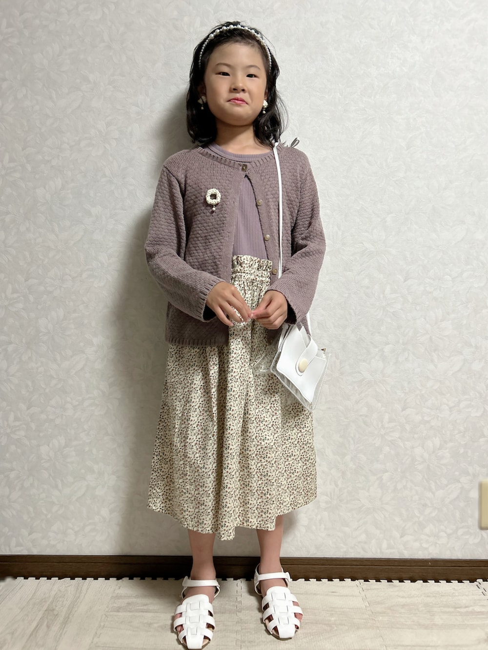 パープル系のワンピース、グレー系のカーディガン/ボレロ、ホワイト系のショルダーバッグを着用したキッズの夏コーディネートの3枚目の写真