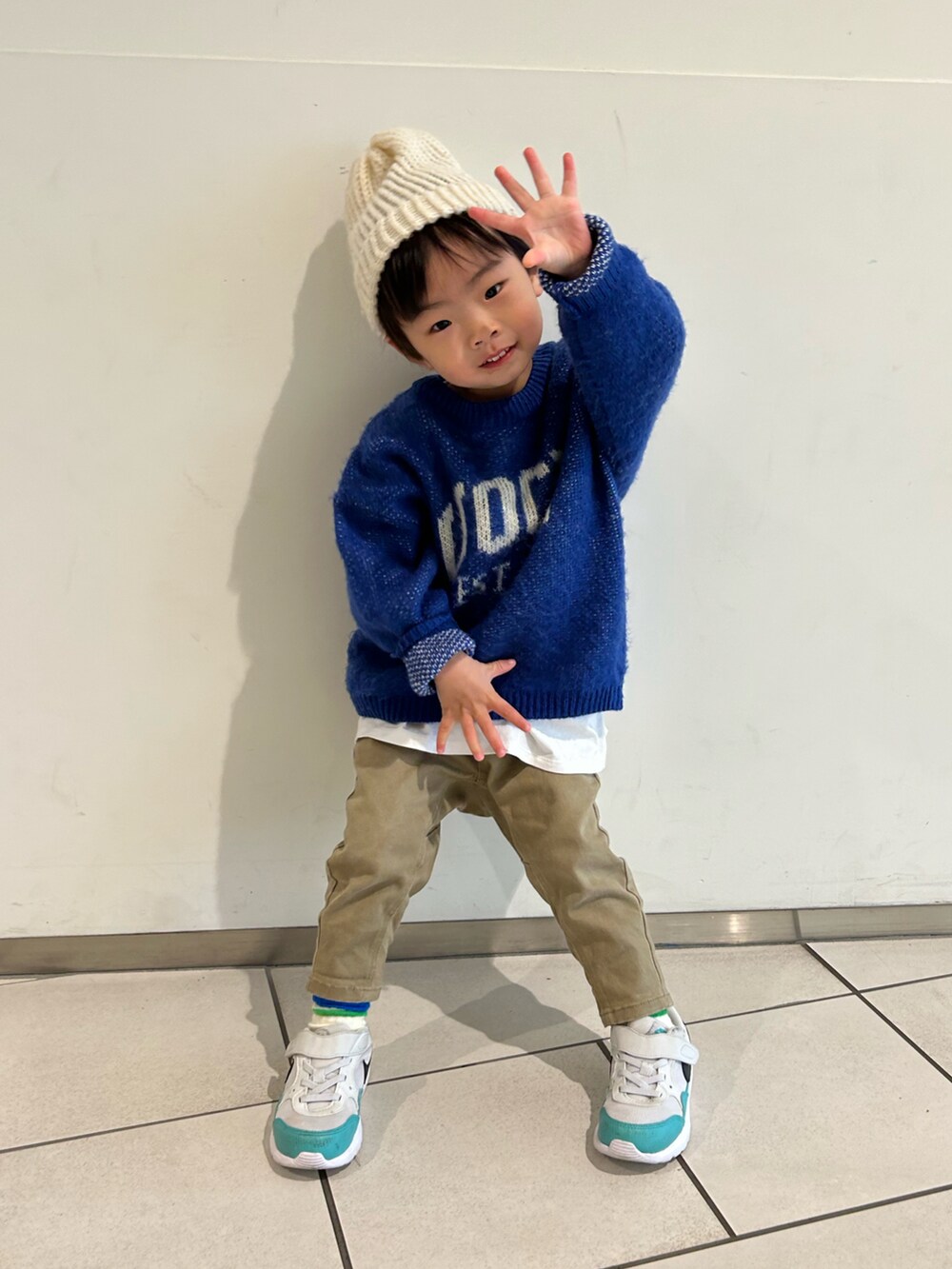 ブルー系のニット/セーター、ベージュ系のその他パンツ、ホワイト系のスニーカーを着用したキッズの冬コーディネートの2枚目の写真