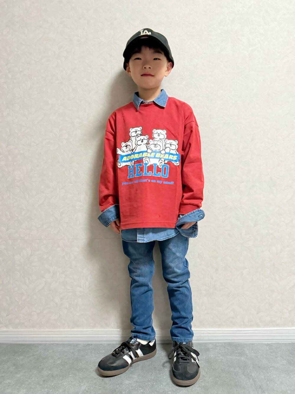 レッド系のTシャツ/カットソー、ブルー系のデニムパンツ、ブラック系のスニーカーを着用したキッズの秋コーディネートの2枚目の写真