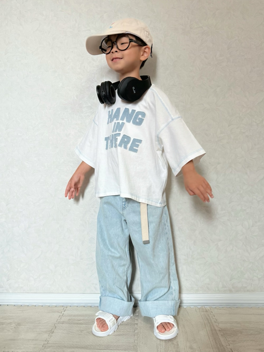 ホワイト系のTシャツ/カットソー、ブルー系のデニムパンツ、ホワイト系のサンダルを着用したキッズの夏コーディネートの3枚目の写真