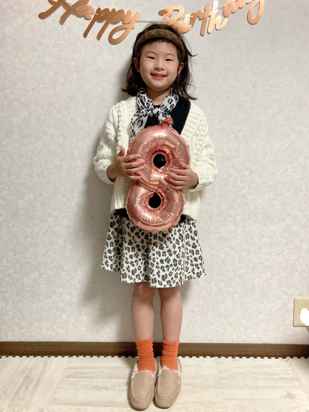 ブラック系のTシャツ/カットソー、ホワイト系のカーディガン/ボレロ、ベージュ系のスカートを着用したキッズの秋コーディネートの4枚目の写真