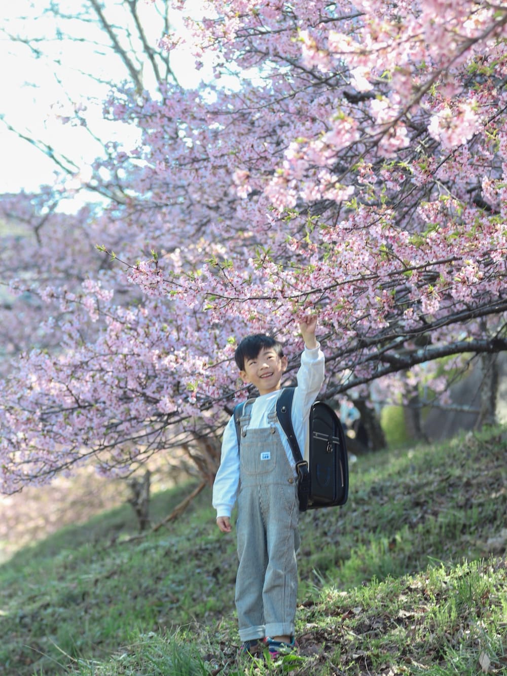 ブラック系のランドセル、グレー系のスニーカー、その他のサロペット/オーバーオールを着用したキッズの春コーディネートの3枚目の写真