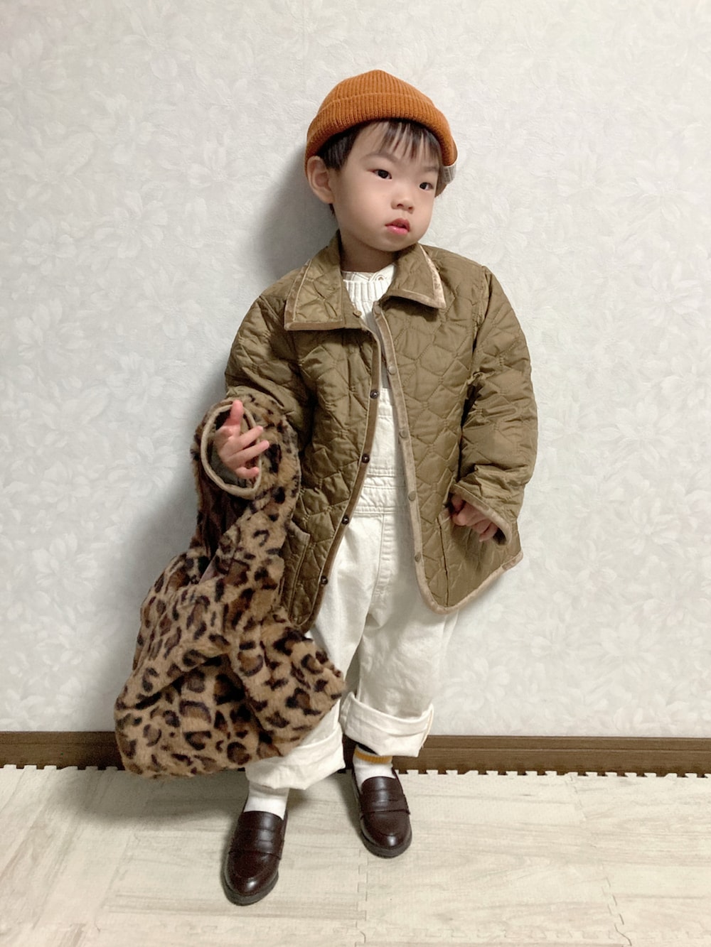 ベージュ系のシャツ/ブラウス、ホワイト系のニット/セーター、グリーン系のブルゾンを着用したキッズの秋コーディネートの2枚目の写真