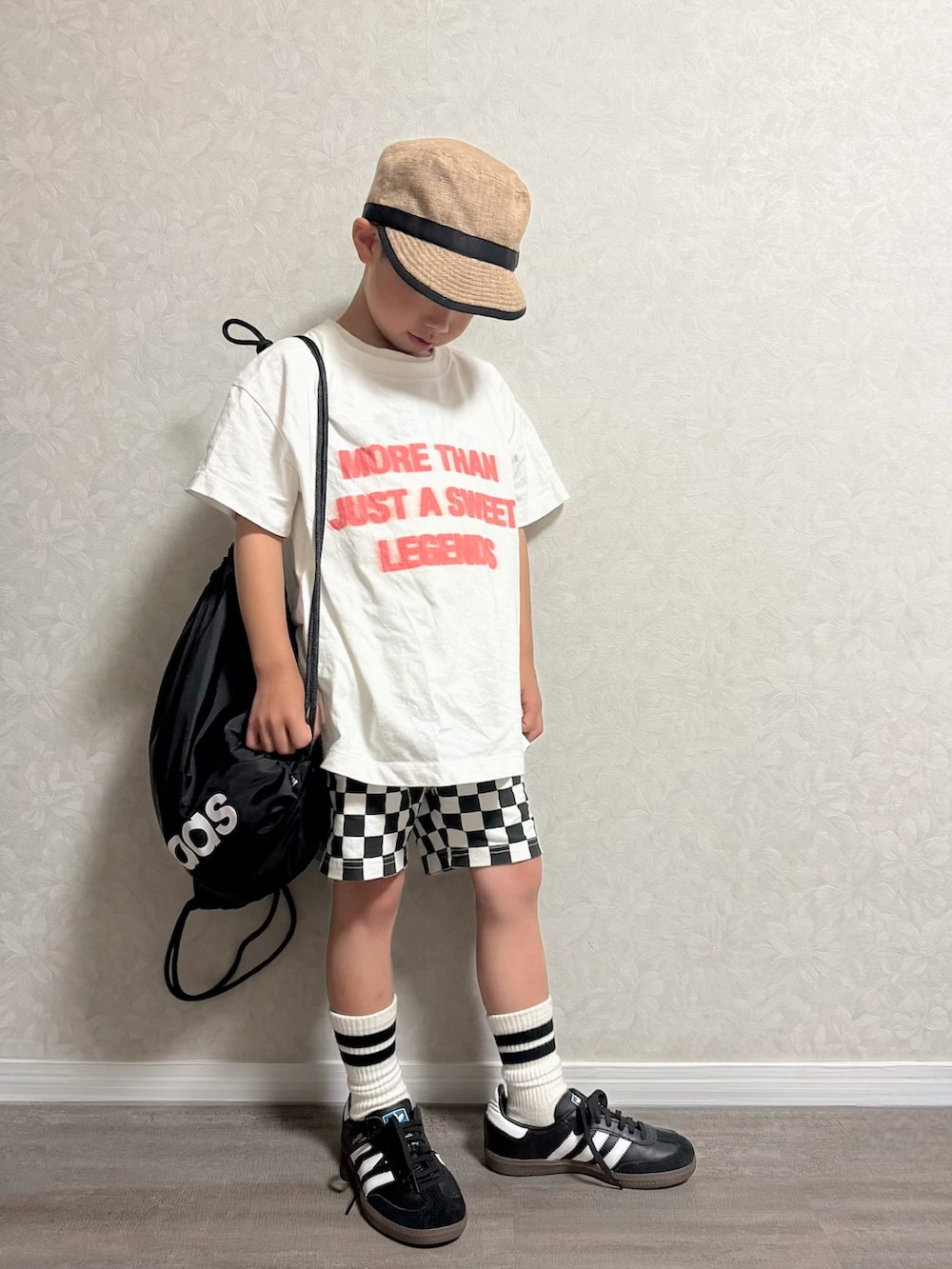 ブラック系のバックパック/リュック、ブラック系のスニーカー、ホワイト系のTシャツ/カットソーを着用したキッズの夏コーディネートの3枚目の写真