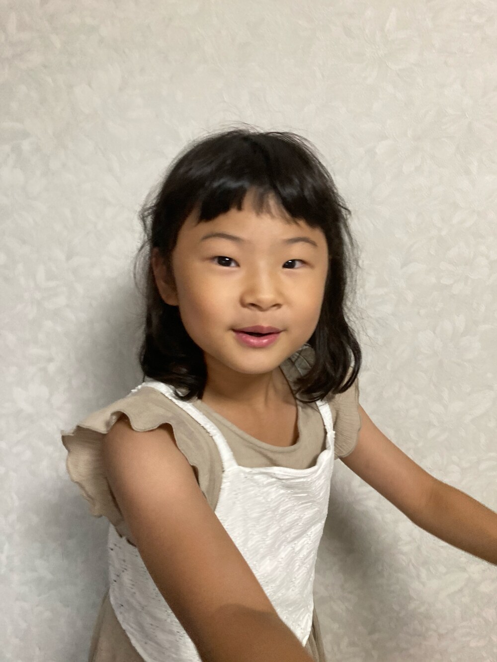 ベージュ系のワンピース、ホワイト系のキャミソール、ブラウン系のショルダーバッグを着用したキッズの夏コーディネートの5枚目の写真