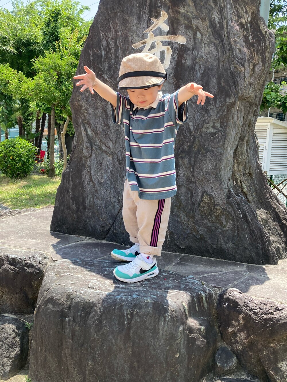 グリーン系のポロシャツ、ベージュ系のその他パンツ、ホワイト系のスニーカーを着用したキッズの春コーディネートの3枚目の写真