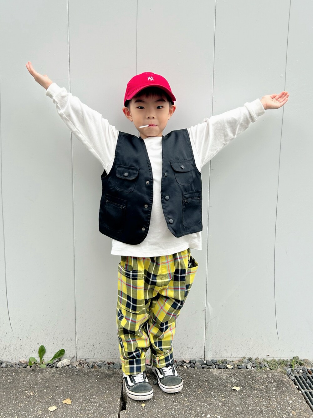 ホワイト系のTシャツ/カットソー、ブラック系のベスト、レッド系のスタジャンを着用したキッズの秋コーディネートの4枚目の写真