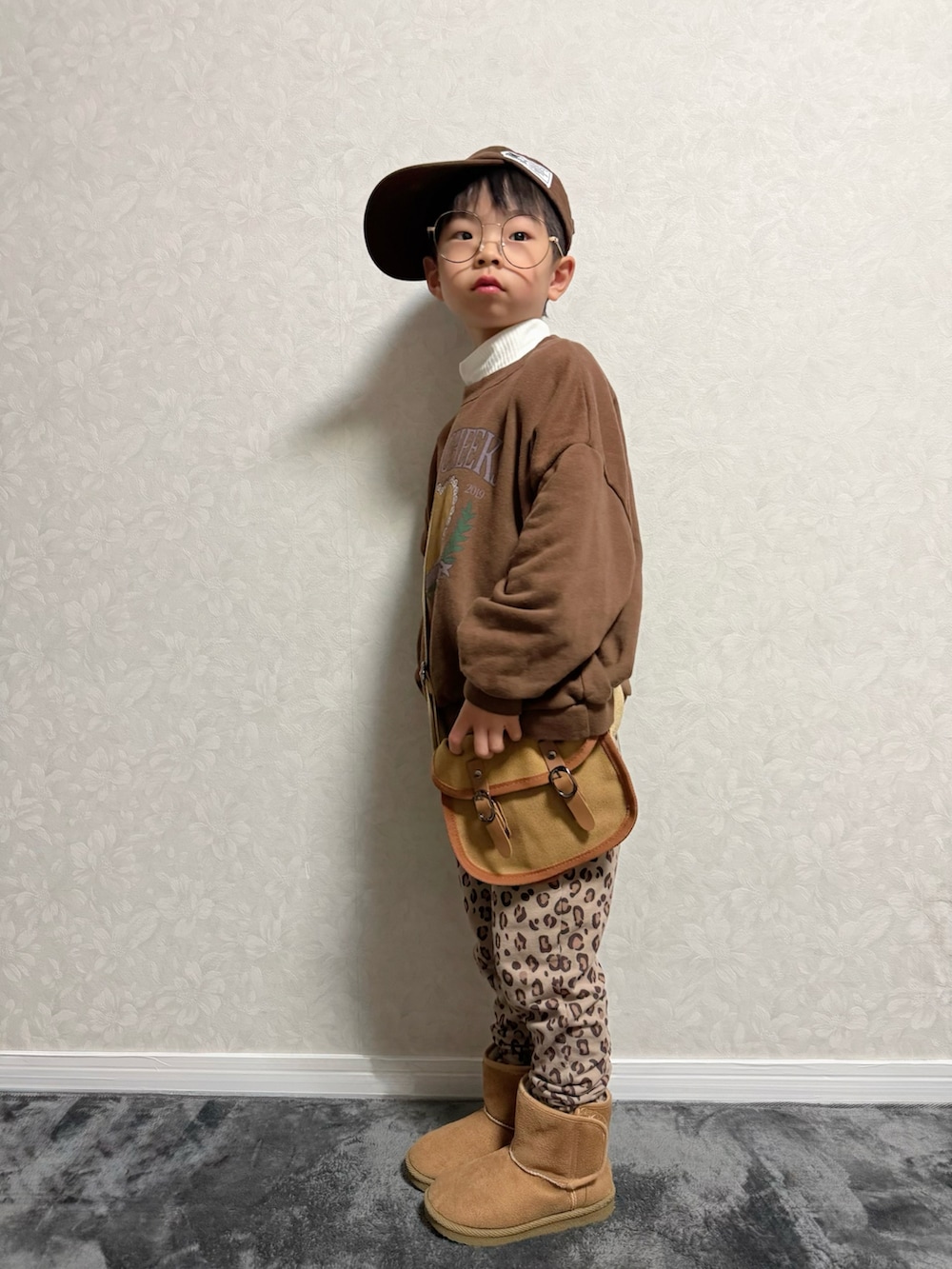 ブラウン系のその他パンツ、ブラウン系のショルダーバッグ、ホワイト系のTシャツ/カットソーを着用したキッズの冬コーディネートの3枚目の写真