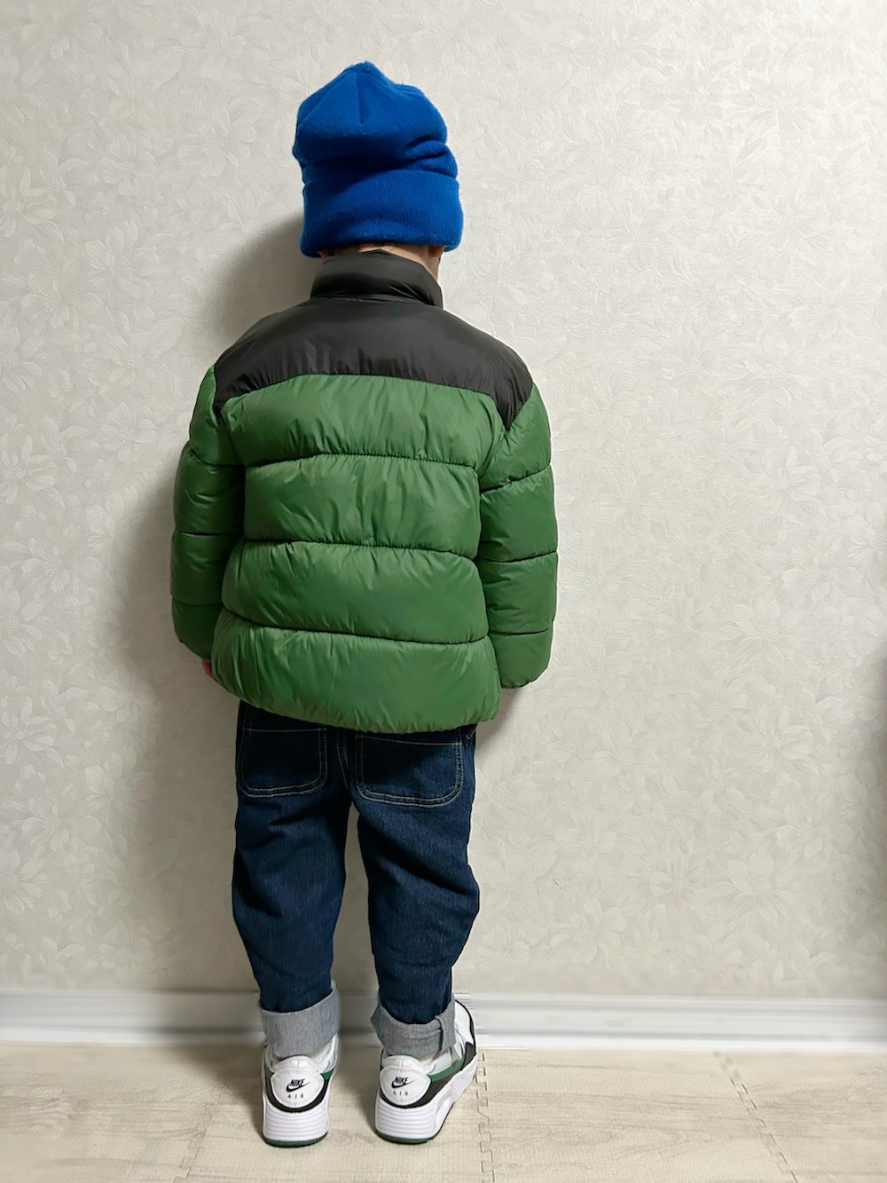 ホワイト系のTシャツ/カットソー、グリーン系のダウンジャケット/コート、ブルー系のデニムパンツを着用したキッズの冬コーディネートの5枚目の写真