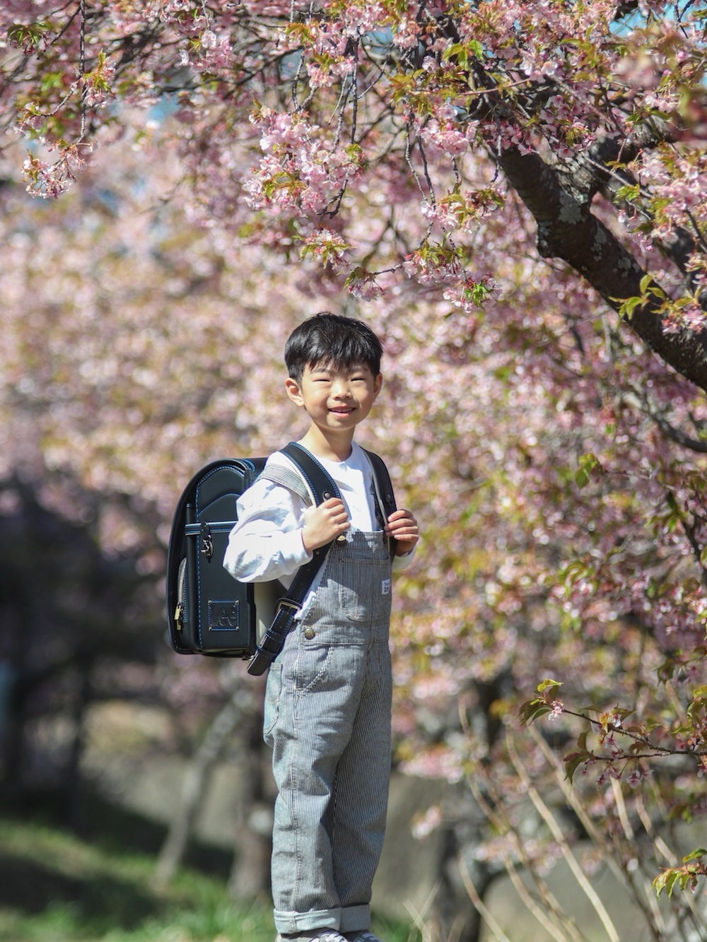 ブラック系のランドセル、グレー系のスニーカー、その他のサロペット/オーバーオールを着用したキッズの春コーディネートの4枚目の写真