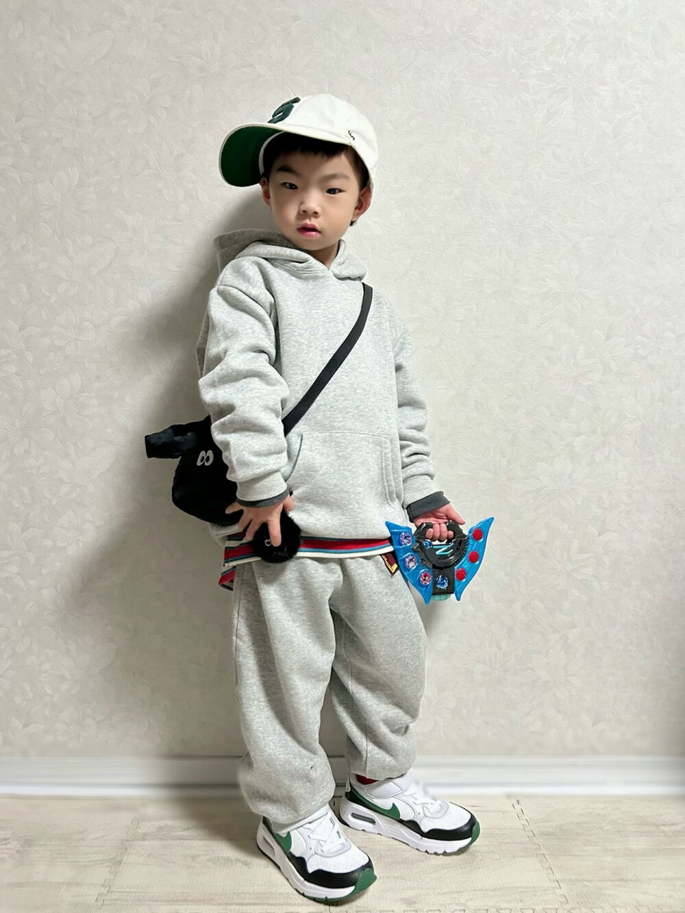 グレー系のパーカー、レッド系のTシャツ/カットソー、グレー系のスウェットパンツを着用したキッズの冬コーディネートの2枚目の写真