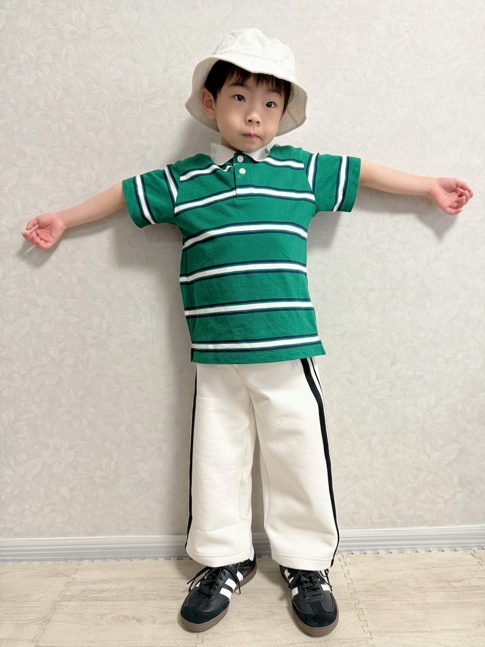 ホワイト系のナイロンジャケット、グリーン系のポロシャツ、ホワイト系のスウェットパンツを着用したキッズの冬コーディネートの5枚目の写真