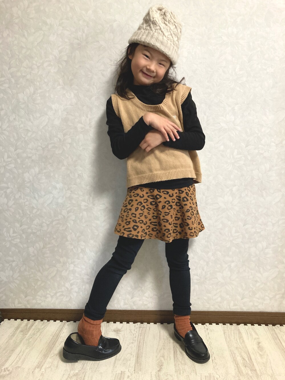 ブラック系のニット/セーター、ベージュ系のベスト、ブラウン系のスカートを着用したキッズの冬コーディネートの2枚目の写真