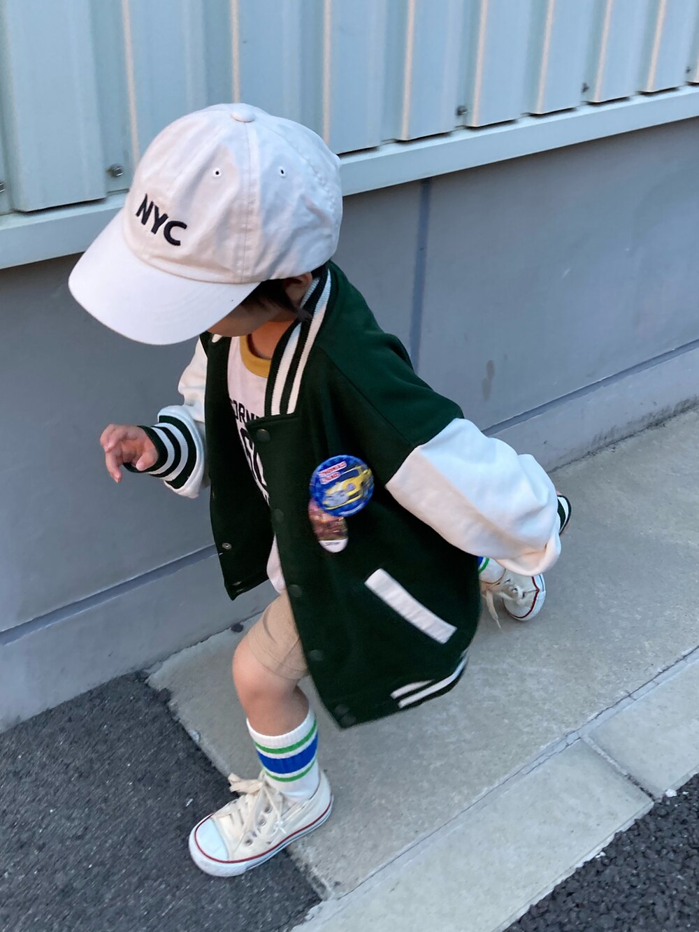 ホワイト系のTシャツ/カットソー、ベージュ系のパンツ、グリーン系のブルゾンを着用したキッズの秋コーディネートの5枚目の写真