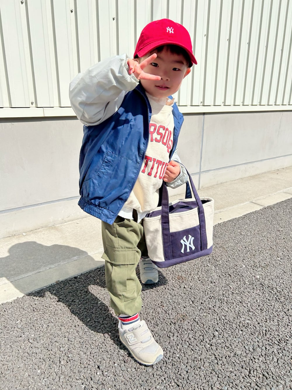 ブルー系のナイロンジャケット、ホワイト系のシャツ/ブラウス、ホワイト系のスウェットを着用したキッズの春コーディネートの3枚目の写真