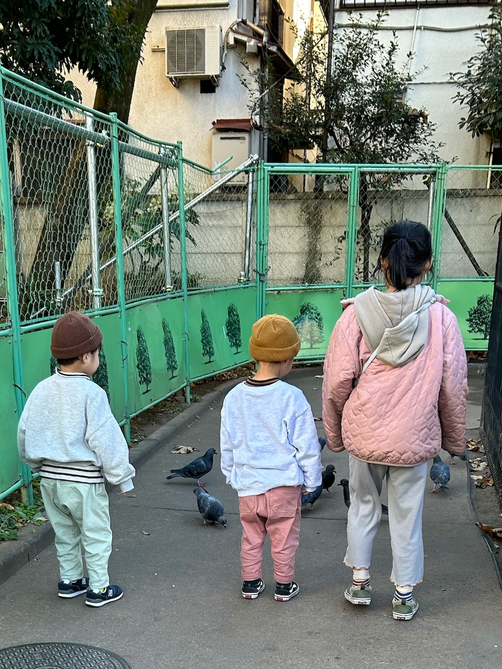 ブラウン系のTシャツ/カットソー、グレー系のスウェット、ピンク系のチノパンツを着用したキッズの冬コーディネートの3枚目の写真