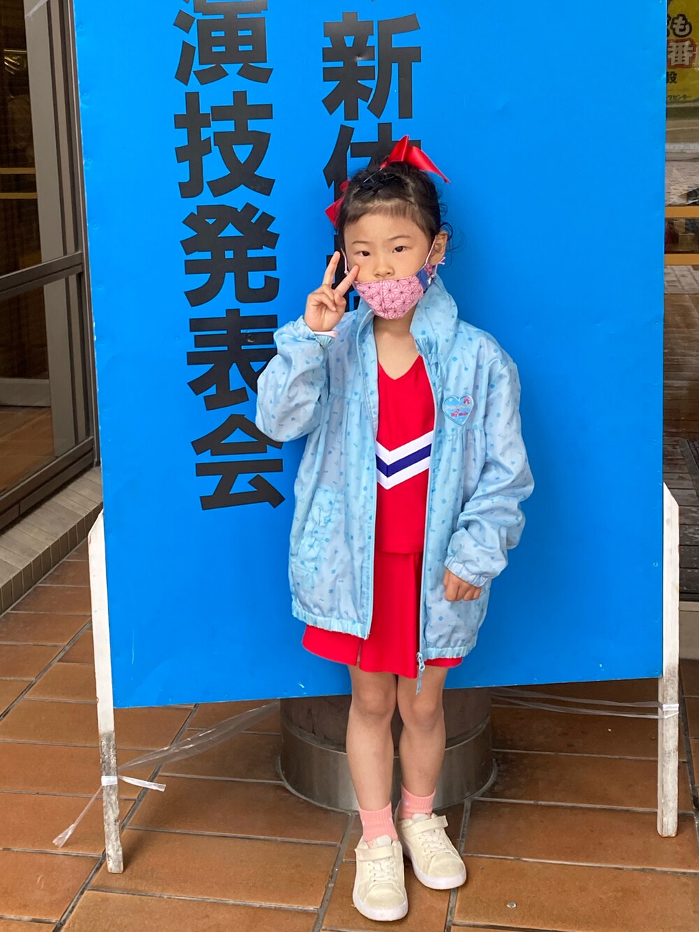 オレンジ系のTシャツ/カットソー、グリーン系のパンツ、ブラック系のサンダルを着用したキッズの夏コーディネートの5枚目の写真