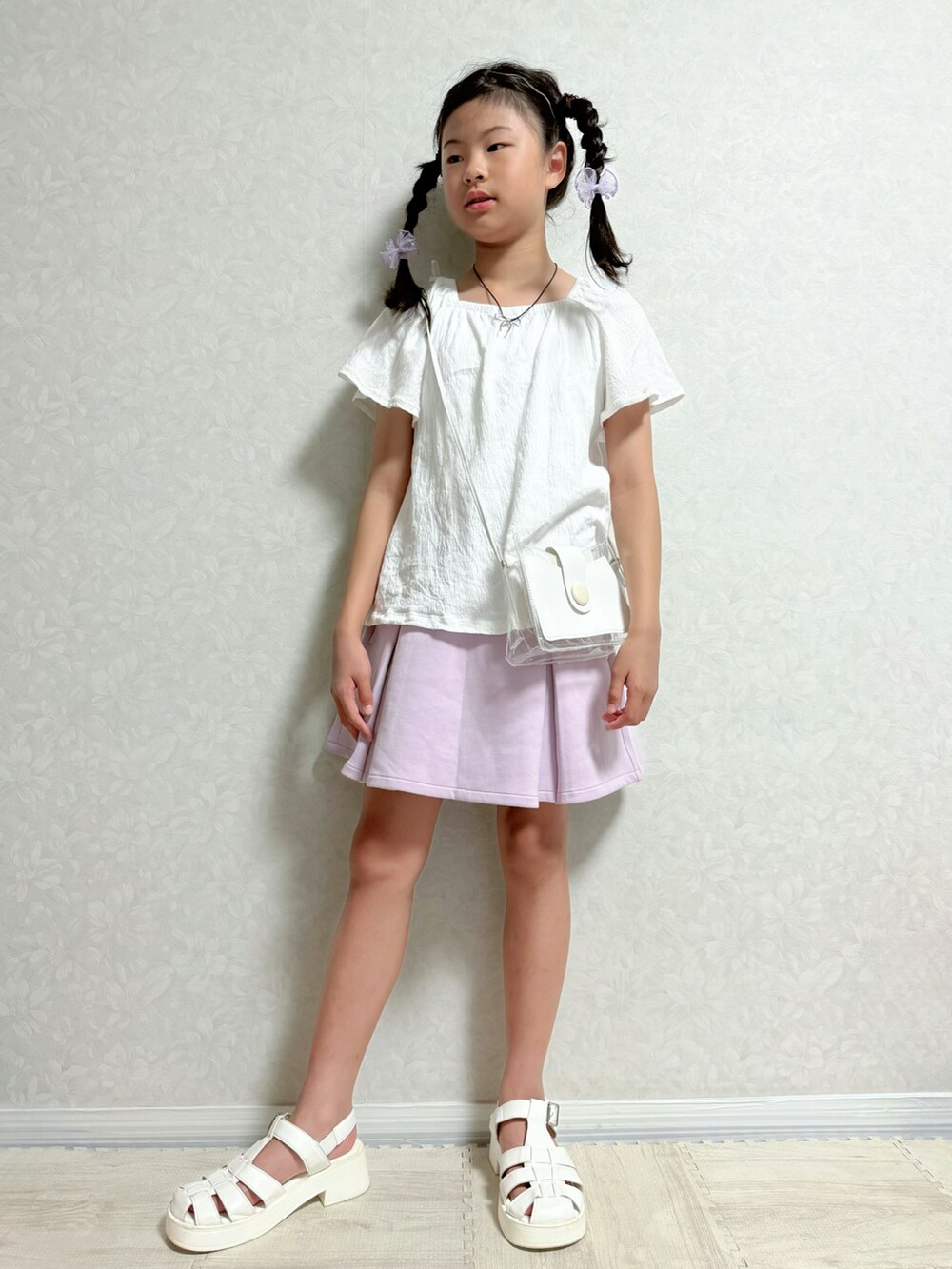 ホワイト系のサンダル、ホワイト系のTシャツ/カットソー、パープル系のスカートを着用したキッズの夏コーディネートの2枚目の写真