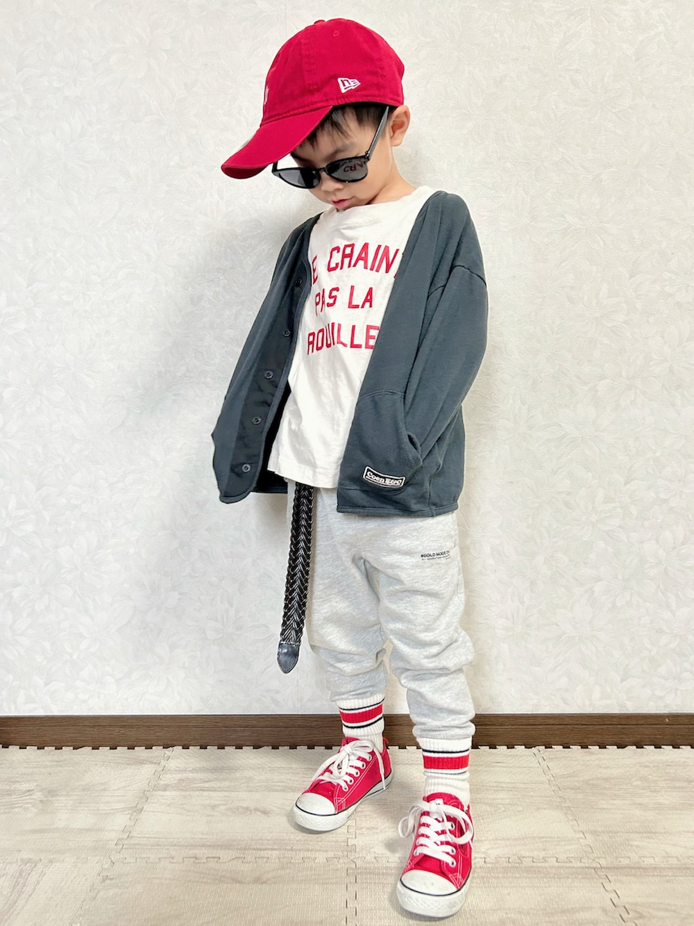 ブラック系のカーディガン/ボレロ、ホワイト系のTシャツ/カットソー、グレー系のスウェットパンツを着用したキッズの秋コーディネートの4枚目の写真