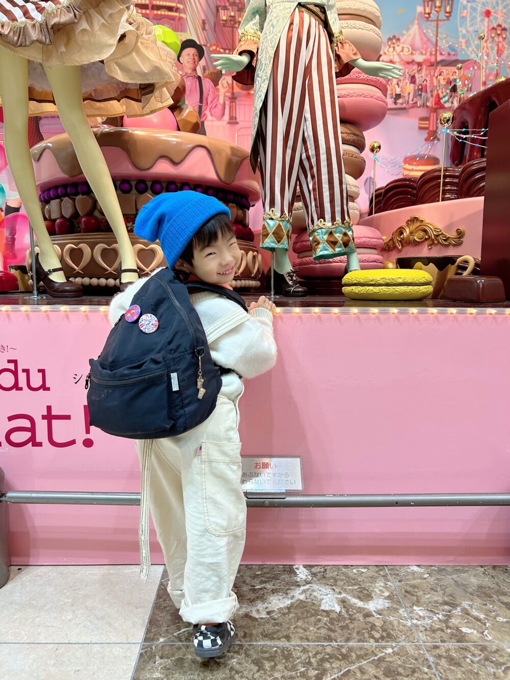 ホワイト系のニット/セーター、ホワイト系のサロペット/オーバーオール、オレンジ系のスウェットを着用したキッズの冬コーディネートの3枚目の写真