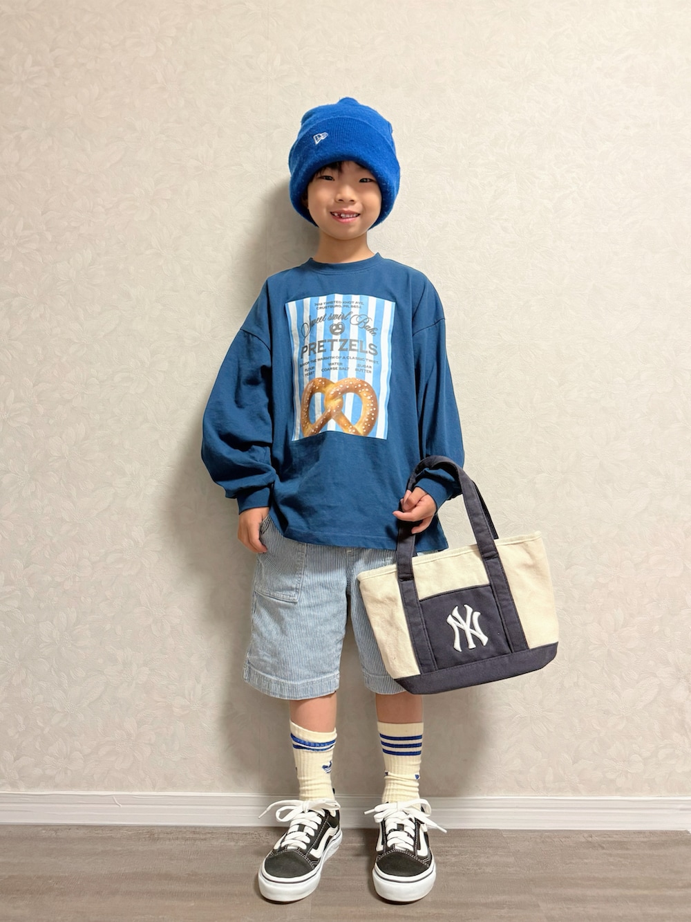 ブルー系のTシャツ/カットソー、ホワイト系のショルダーバッグ、ブラック系のスニーカーを着用したキッズの秋コーディネートの2枚目の写真
